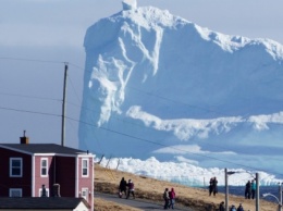 В канадскую деревню приплыл гигантский айсберг. Туристы постят в соцсетях удивительные фото