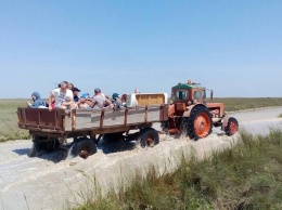 Отдыхающих эвакуируют с острова до запорожского курорта на тракторах (Фото)
