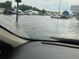 Вырванные номерные знаки и пробки на дорогах: В Киеве прошел сильный дождь