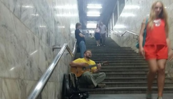 Противника Кернеса играет на гитаре в переходе метро