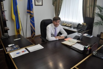 Рабочий кабинет начальника запорожской налоговой: пустой стол, книги и множество икон