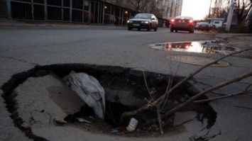 В Одессе посреди дороги образовалась гигантская яма, размером с автомобиль