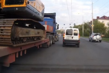 В Омске легковые машины живым щитом блокировали трейлер с экскаватором