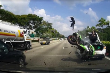 Мотоциклист взмыл в воздух, врезавшись в стоящий автомобиль (видео)