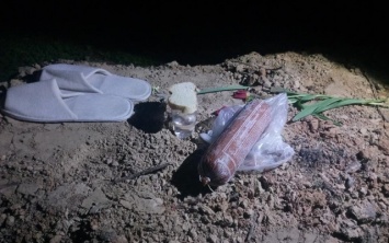Фотофакт: В центре города на "могилу" принесли колбасу и тапочки