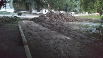 В Енакиево поменяли трубу, но не закопали яму. Над узким проходом к дому падает плитка (фото)