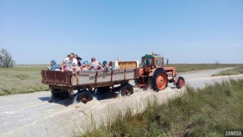 Отдыхающих эвакуируют с острова до запорожского курорта на тракторах (Фото)