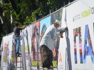 Подготовка к строительству: вокруг сквера Яланского рабочие устанавливают ограждение с рекламой будующего ТРЦ