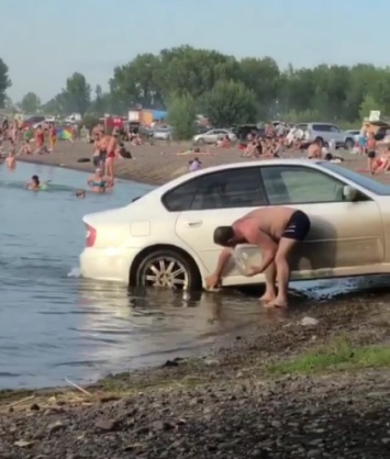 В Красноярске наглый водитель помыл машину в озере, в котором плавали дети