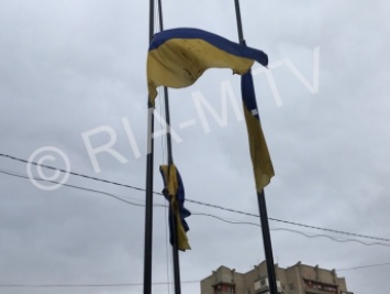 На площади нерадивый подрядчик измазал государственные флаги черной краской (фото)