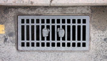 «Дню милиции посвящается»: художник превратил канализационную решетку напротив Кремля в тюремную
