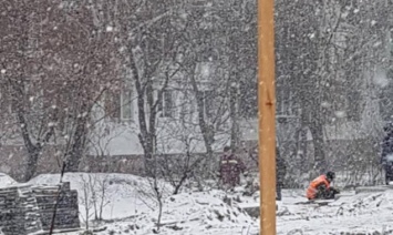В Бортничах к зиме решили начать ремонтировать сквер, рабочие укладывают плитку прямо в грязь