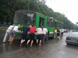 На Салтовке пассажиры под дождем толкали до остановки обесточенный троллейбус (ФОТО)