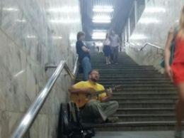 Противника Кернеса играет на гитаре в переходе метро