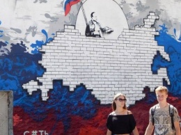 В Севастополе появились граффити с Путиным, закрывающим свет солнца России
