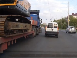 В Омске легковые машины живым щитом блокировали трейлер с экскаватором