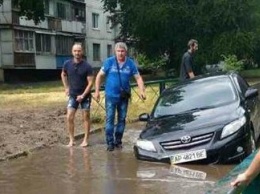 В Запорожье иномарка утонула в огромной яме, которую на днях засыпали коммунальщики (ВИДЕО)