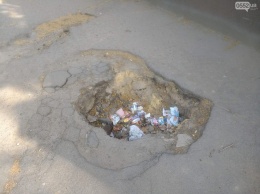 Херсонцы превращают дыры в асфальте в мусорные урны
