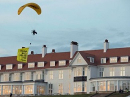 В Шотландии парапланерист из Greenpeace пролетел над курортом Трампа с протестным плакатом, его задержали