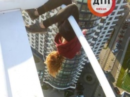 "Илона зависает". Сеть шокировали фото девушки-экстремалки, которая повисла вниз головой на парапете киевской высотки