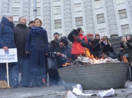 Матери со всех областей Украины под стенами Кабмина в знак протеста сожгли квитанции за оплату услуг ЖКХ