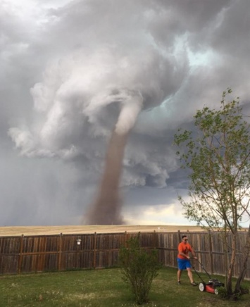 Появилось фото, как "Чак Норрис газонокосилок" спокойно убирает двор на фоне надвигающегося торнадо