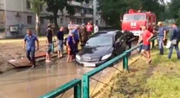 В Запорожье автомобиль застрял в затопленной ливнем яме (Видео)