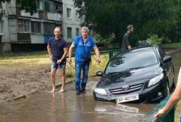 В Запорожье иномарка утонула в огромной яме, которую на днях засыпали коммунальщики (ВИДЕО)