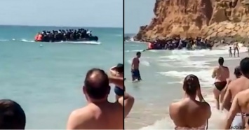 Смотрите, как 50 мигрантов высаживаются на пляж и разбегаются - на глазах у туристов!